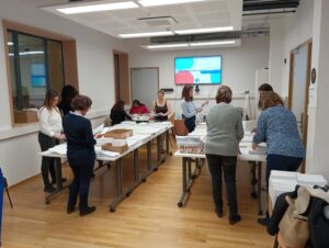 Image de l'évènement d'assemblage des kits montrant une grande partie de l'équipe tournant autour de différentes tables pour récupérer les gabarits et assembler les kits